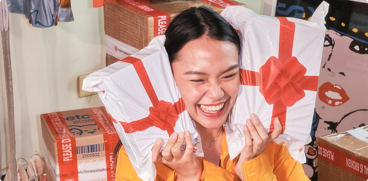 Happy MyShoppingBox customer holding gift-wrapped packages